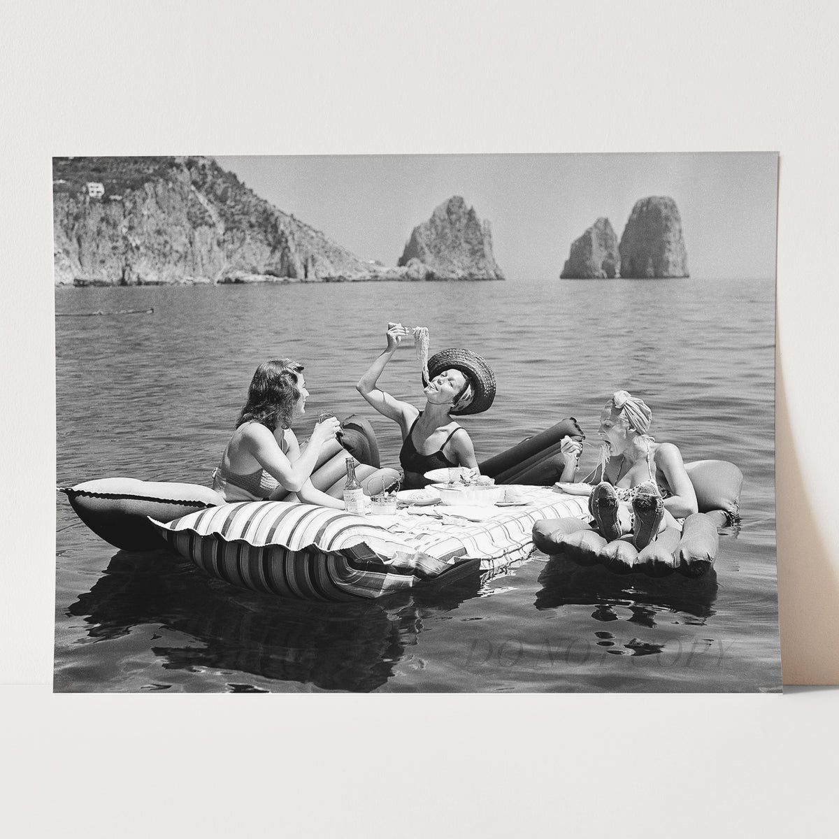 Floating Luncheon, three young women eat spaghetti on inflatable mattresses at Lake of Capri, 1939