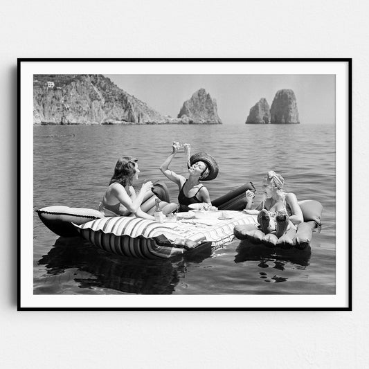 Floating Luncheon, three young women eat spaghetti on inflatable mattresses at Lake of Capri, 1939